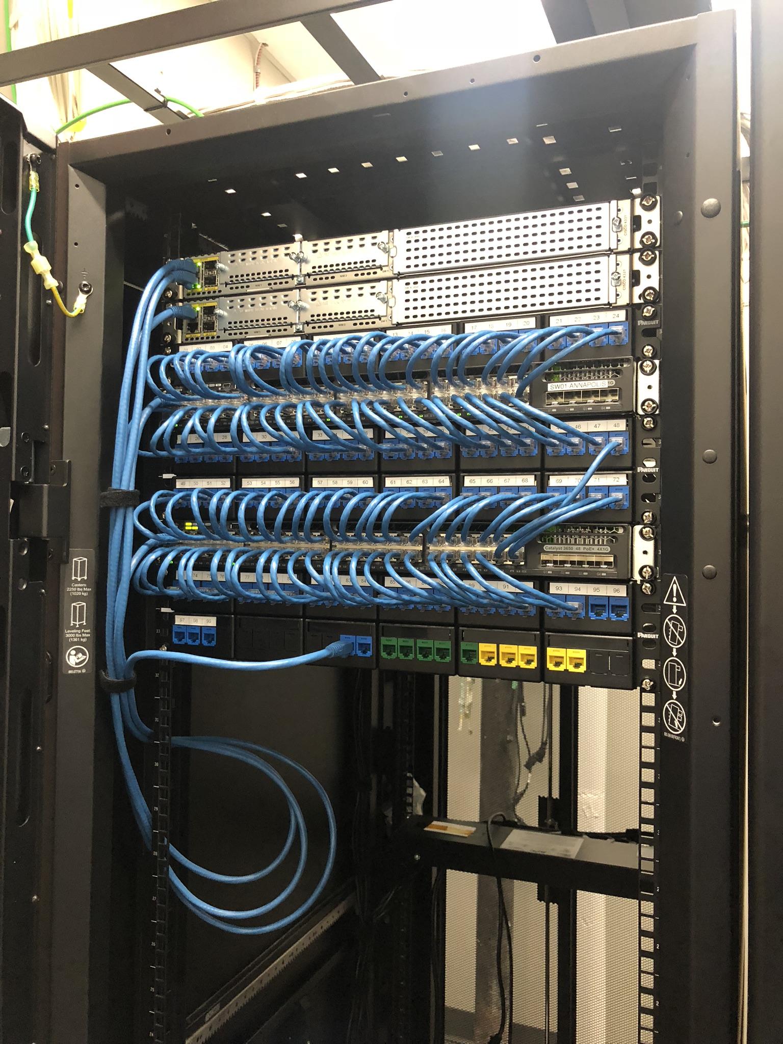 Equipamentos de rede e organização de cabos em rack corporativo